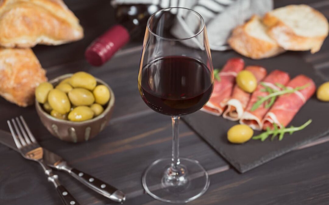 red wine in wine glass surrounded by food